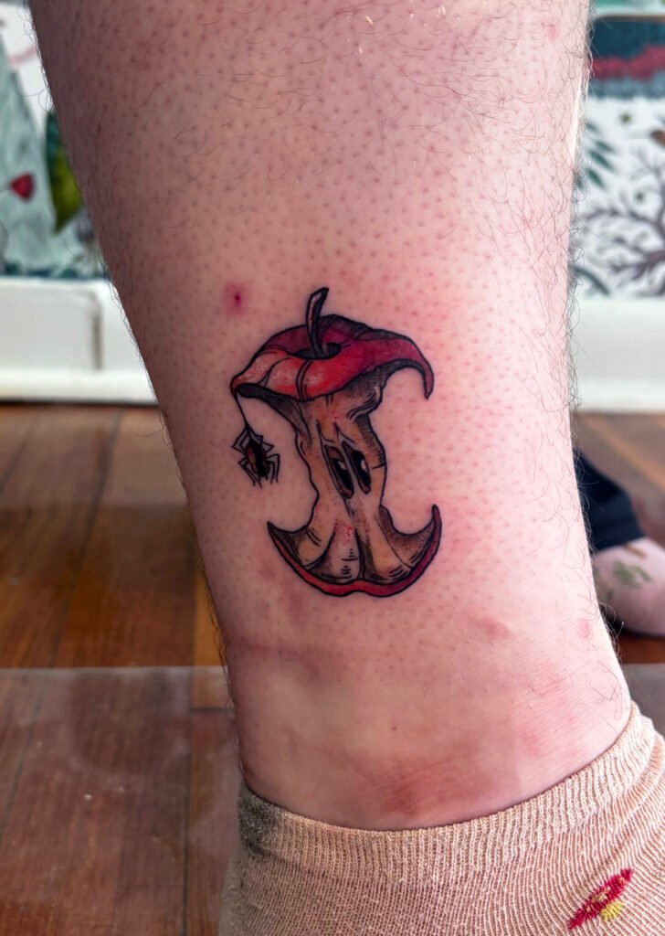 Red apple core with small spider color tattoo illustration realism style.